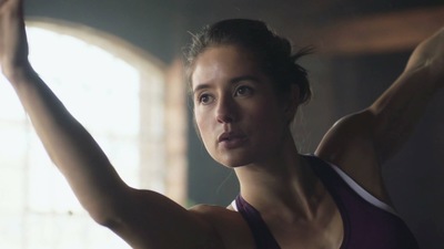 a woman in a tank top is holding her arm up