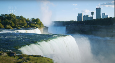 a view of a waterfall with a city in the background