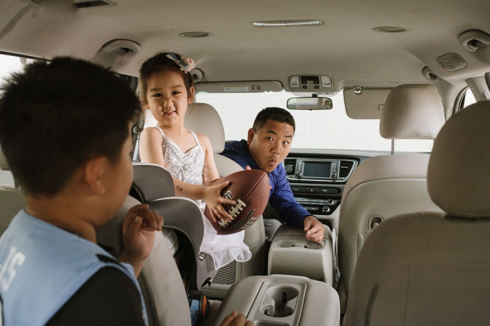 a couple of kids sitting in the back of a car