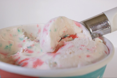 a scoop of ice cream in a cup with sprinkles