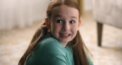 a little girl with long hair sitting on the floor