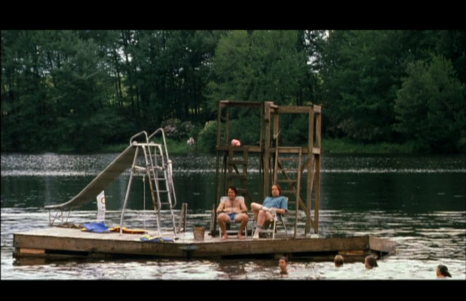 a group of people sitting on top of a wooden raft