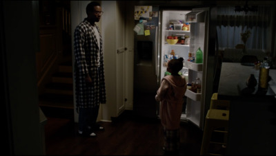 a man and a little girl standing in front of a refrigerator