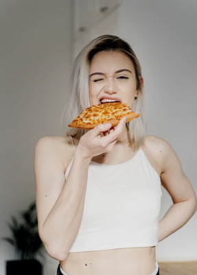 a woman is eating a slice of pizza