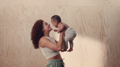 a woman holding a baby up in the air