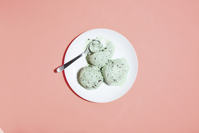 a white plate topped with green cookies on top of a pink table