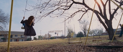 a woman standing on a swing in a park