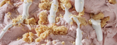 a close up of a dessert with icing and crumbs