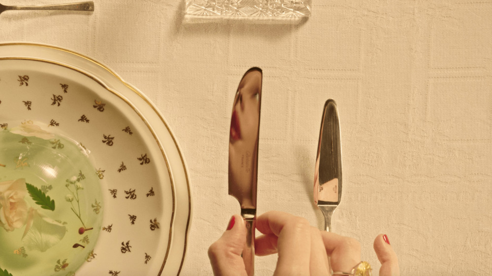 a woman is holding a knife and a plate