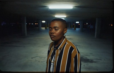 a woman standing in a parking garage with her eyes closed