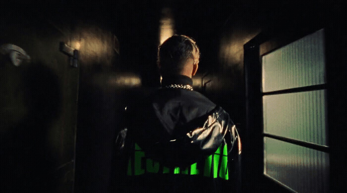 a man standing in front of a window in a dark room