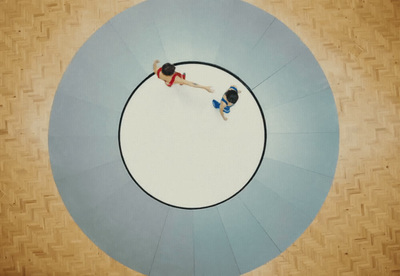 a couple of people standing on top of a circular object