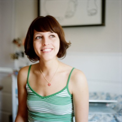 a woman in a green and white tank top smiling