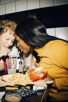 a couple of people sitting at a table with food