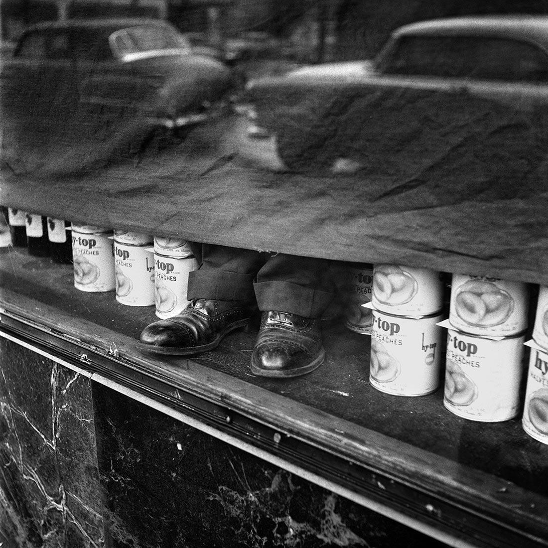 a black and white photo of a shelf with cups