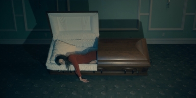 a woman laying on top of a suitcase in a room