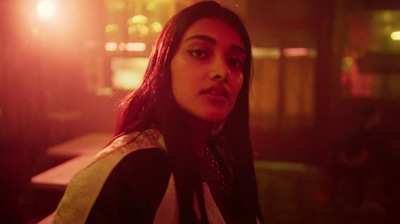 a woman with long hair standing in a dark room