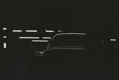 a black and white photo of a car in the dark