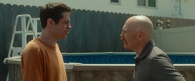 two men standing next to each other near a pool