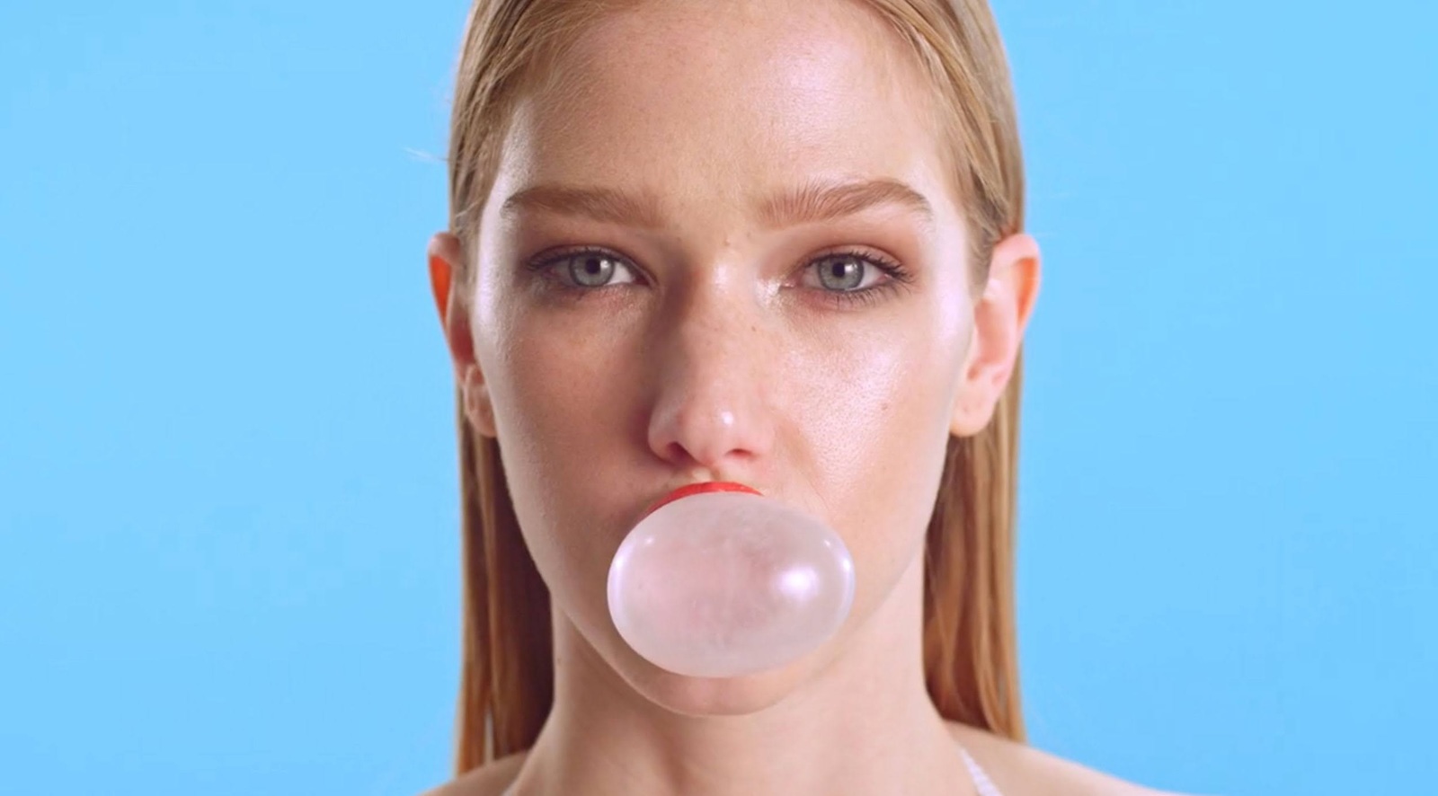 a woman blowing a bubble on her nose