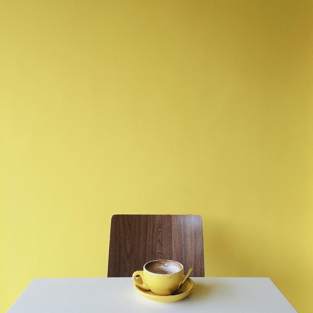 a cup of coffee sitting on top of a white table