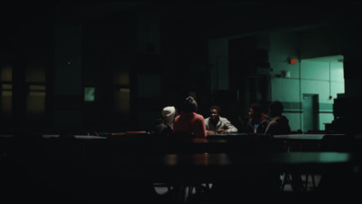 a group of people sitting at a table in a dark room