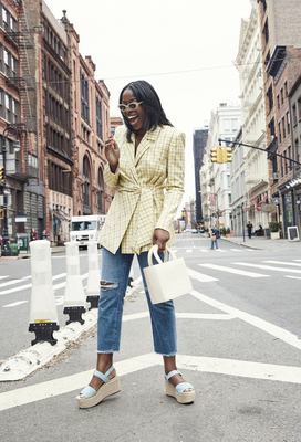 a woman is crossing the street in a city