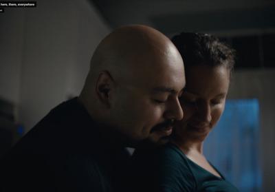 a man and a woman standing together in a dark room