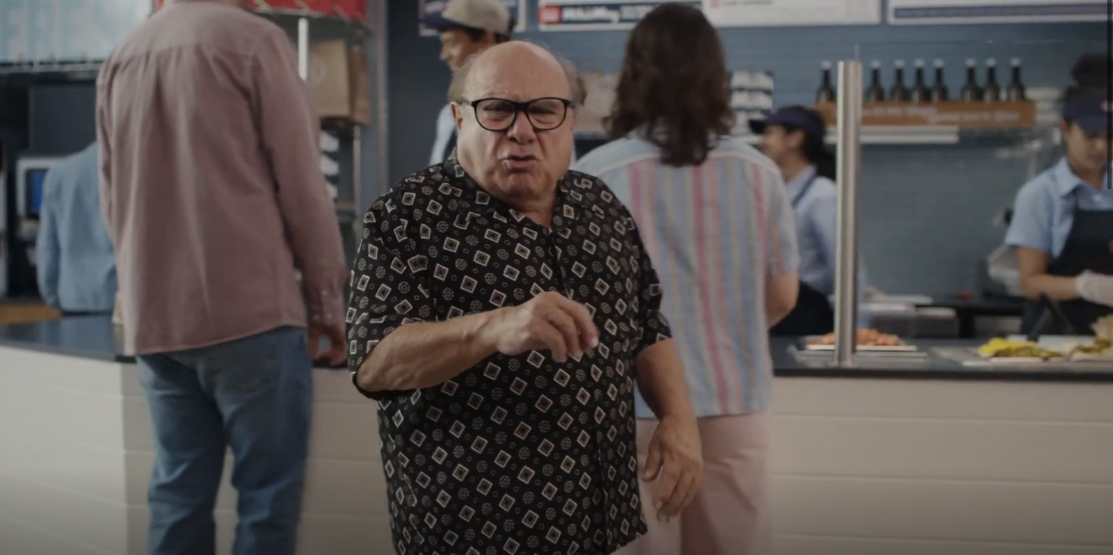 a man standing in a kitchen next to a woman