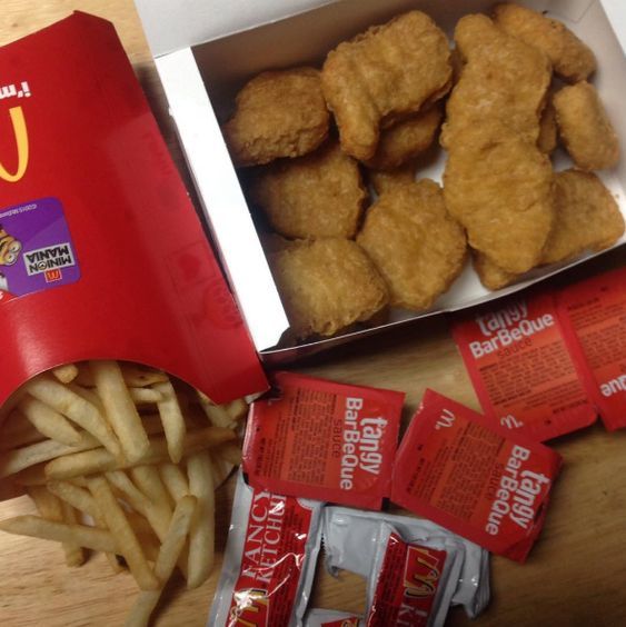 a box of chicken nuggets next to a box of french fries