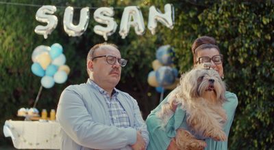 a man and a woman standing next to a dog