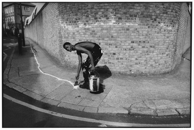 a black and white photo of a man with a bucket