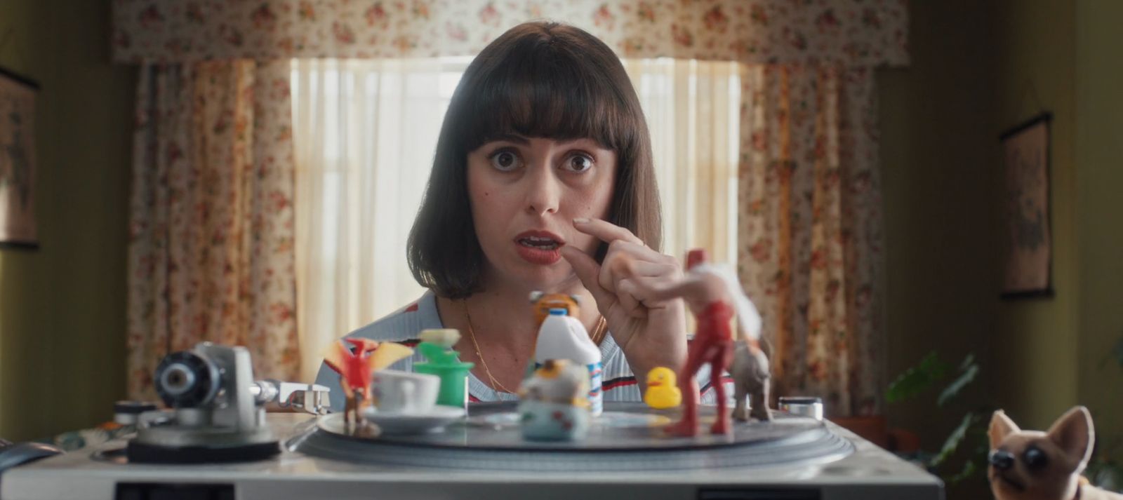 a woman holding a camera in front of a table