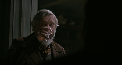 a man with a white beard drinking from a glass