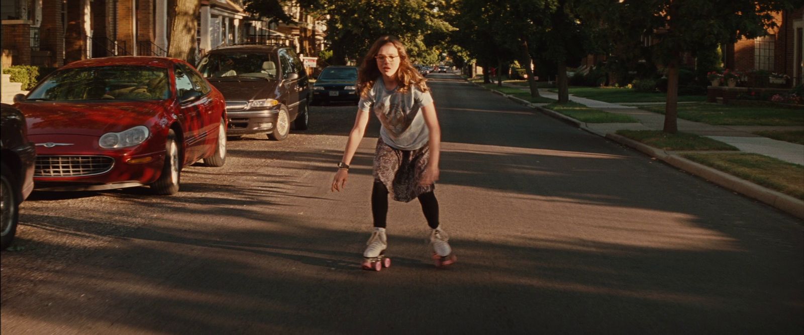 a young girl riding a skateboard down a street