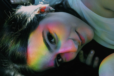 a woman with multicolored makeup laying down