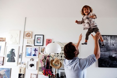 a man holding a little girl up in the air