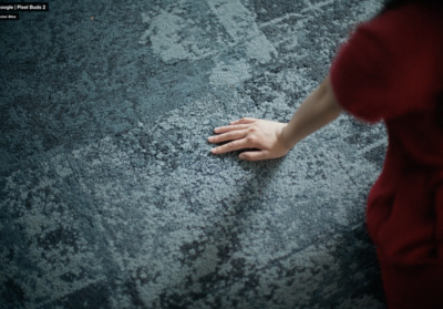 a hand reaching for something on the ground