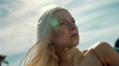 a woman with long blonde hair sitting on the beach