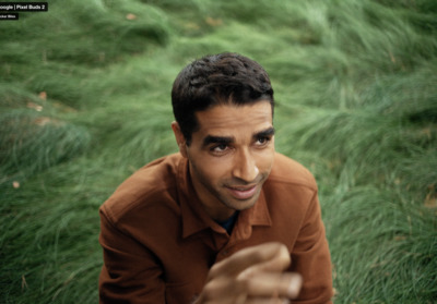 a man sitting in a field of green grass