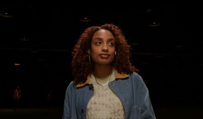 a woman with curly hair standing in the dark