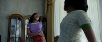 a young girl standing in front of a mirror