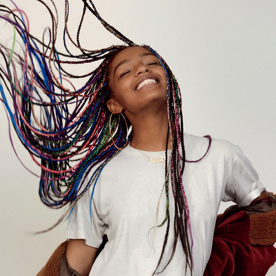 a young girl with long, multi - colored dreadlocks on her hair