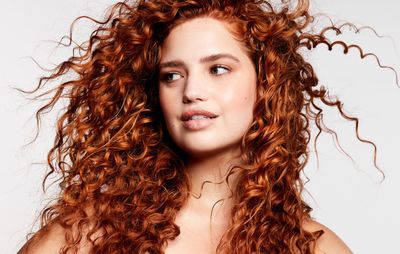 a woman with red curly hair posing for a picture