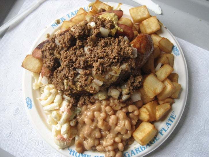 a white plate topped with lots of food on top of a table