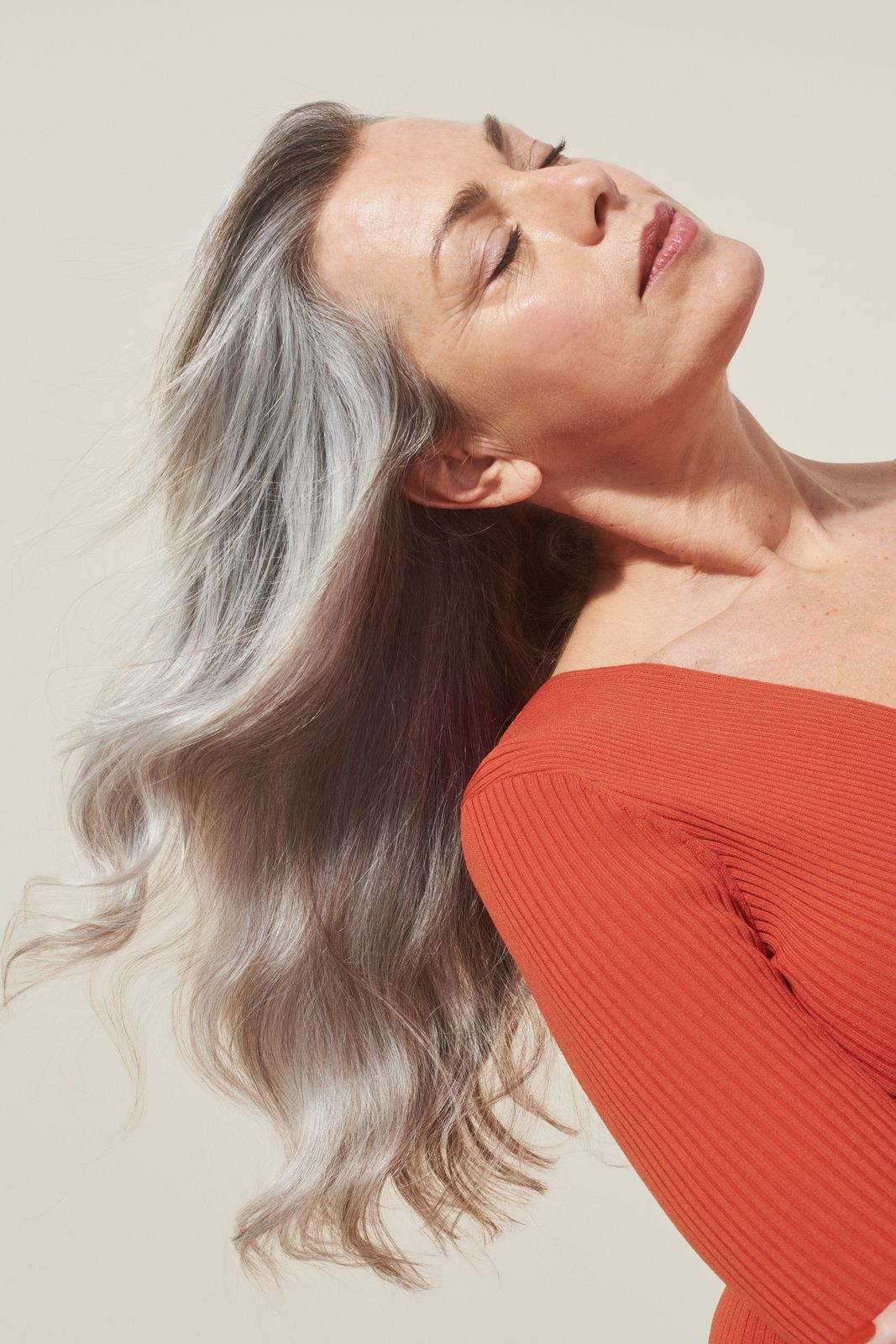 a woman with grey hair and a red top