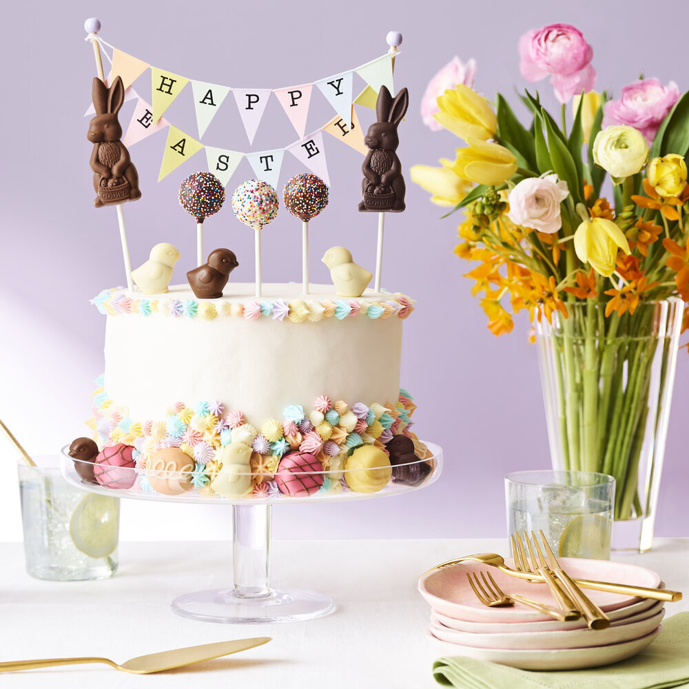 a table with a cake, flowers and a vase of flowers