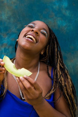 a woman with dreadlocks eating a banana