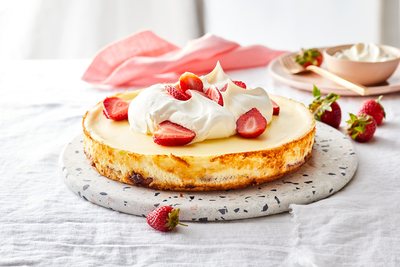 a cheesecake topped with whipped cream and strawberries