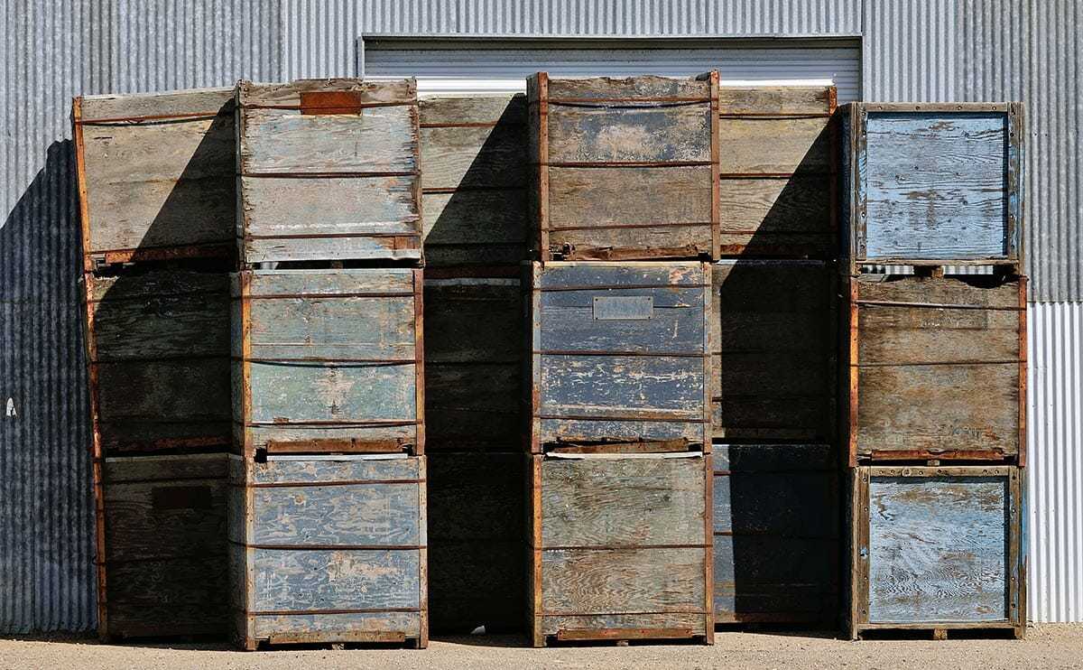 a large stack of wooden crates sitting in front of a building